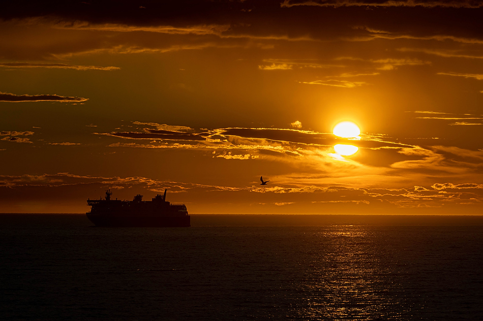Un traversier s’approche du port de Matane au soleil couchant.