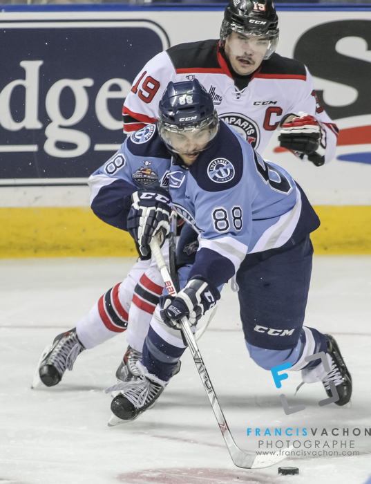 Quebec Remparts forward Kurt Etchegary and Rimouski Oceanic forward  Michael Joly fight for the puck in third period action at the Memorial cup tiebreaker at Le Colisee Pepsi in Quebec city Thursday May 28, 2015.