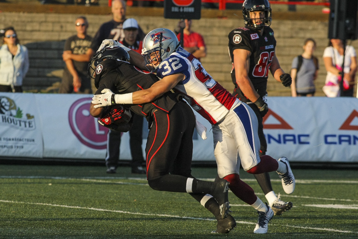 Montreal Alouettes' Mitchell White tacles  Ottawa Redblacks' Ernest Jacson during CFL action in Quebec City on Saturday June 13, 2015. Francis Vachon/Postmedia Network
