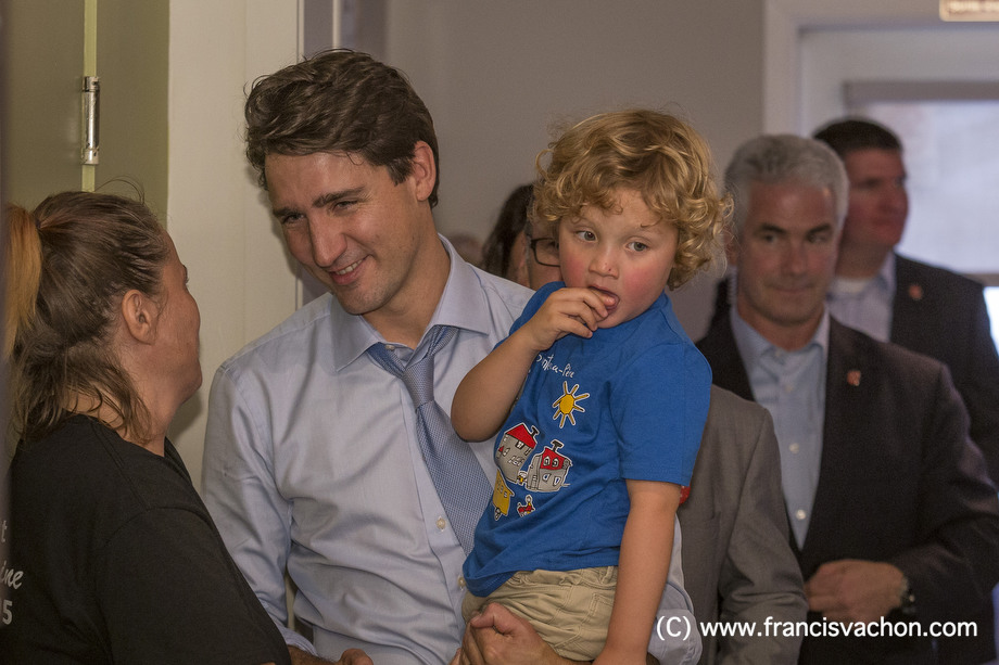 Justin Trudeau shakes hands in a restaurant as he holds his son Hadrien, 3, in Roberval, Qc, on Thursday October 19, 2017. THE CANADIAN PRESS/Francis Vachon.