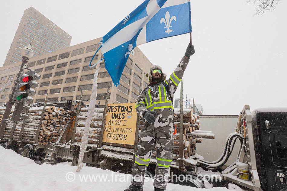 Un homme fait voler un drapeau pendant la manifestation du 19 et 20 février à Québec