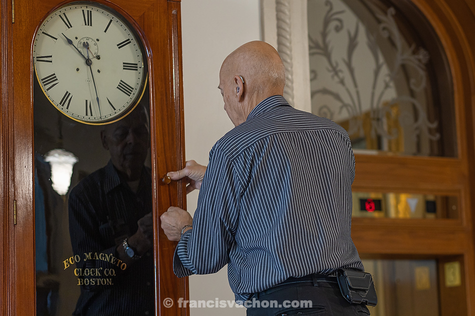 André Viger remonte le mécanisme d’une horloge murale de la Eco Magneto Clock Company de Boston. Son boîtier en acajou contient deux mouvements fabriqués par Seth Thomas, en 1910. Le premier donne l’heure et le second, maintenant inactif, servait à sonner l’appel des députés.