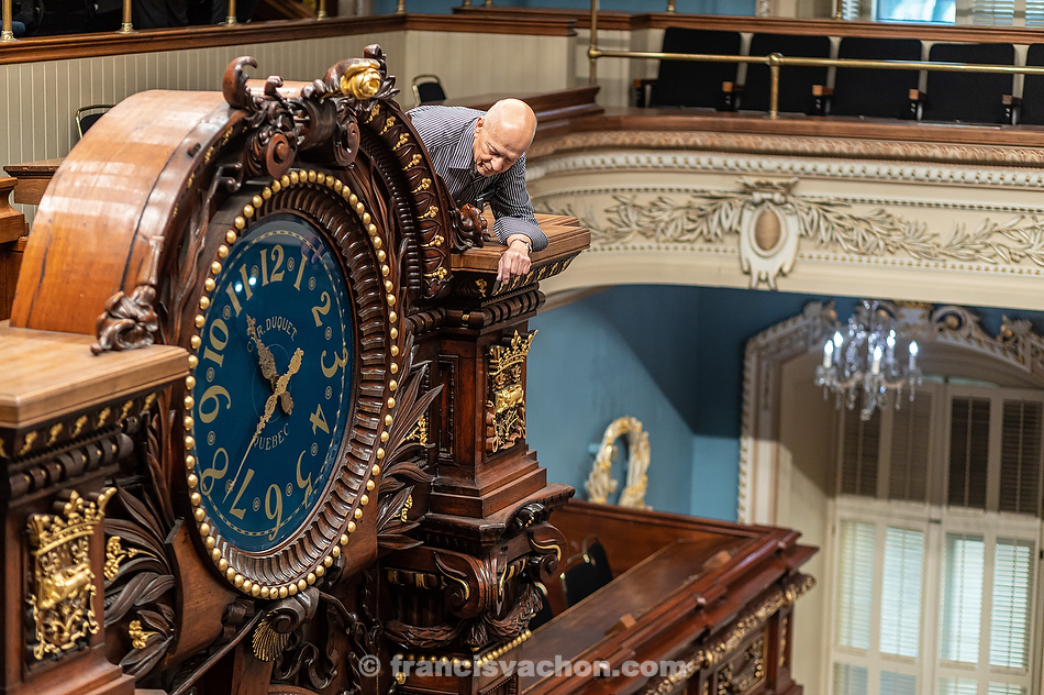 André Viger inspecte le cadran de l’horloge du Salon bleu.