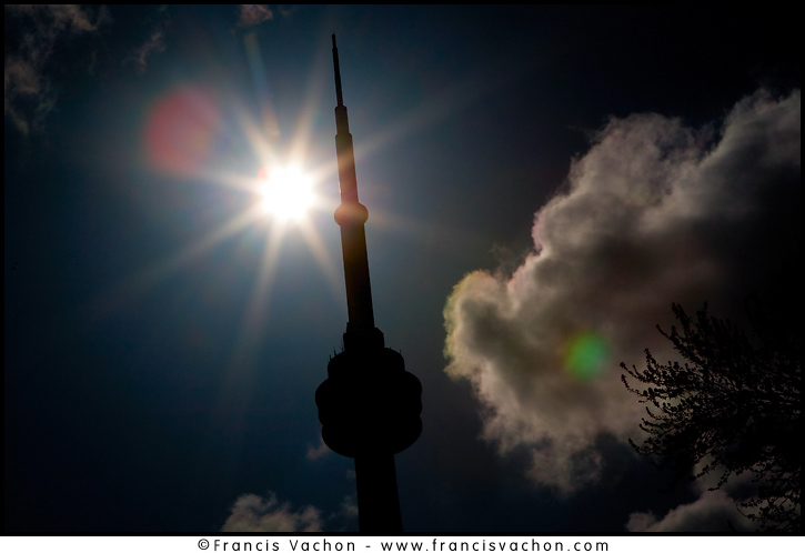 The CN Tower is silhouetted against a bright sun in Toronto. The CN Tower, located in downtown Toronto, Ontario, Canada, is a communications and observation tower standing 553.3 metres (1,815 ft) tall.
