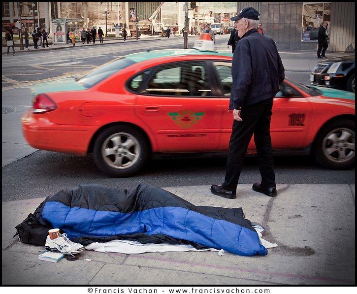 A homeless man sleeps on Queens avenue in downtown Toronto April 19, 2010. 