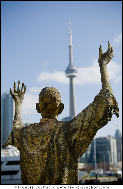 CN Tower is seen behind monument of the Irish Famine Memorial in Toronto.