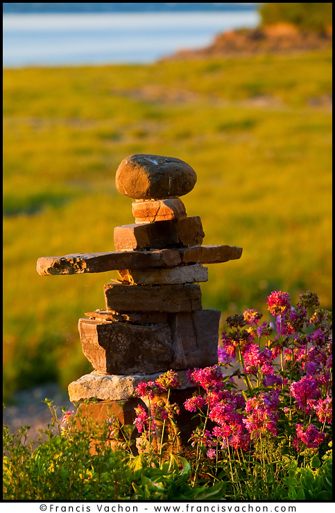 Sun sets on an inuksuk (plural inuksuit) (alternatively inukshuk in English or inukhuk in Inuinnaqtun) in St-Michel de Bellechasse, Qc, August 1th, 2010. Inuksuk is a stone landmark used as a milestone or directional marker by the Inuit of the Canadian Arctic. They vary in shape and size, and perform a diverse array of tasks. It is a symbol with deep roots in the Inuit culture, a directional marker that signifies safety, hope and friendship. 